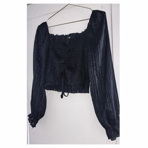 Svart topp med glitter i - Svart snygg topp (lite croppad) med liten puffärm (Går även att ha den nedanför axlarna så sitter den annorlunda) stretchig