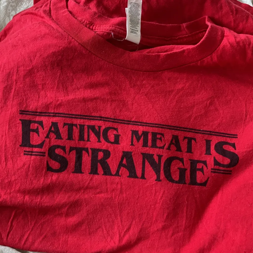 Snygg T-shirt i klarröd färg. Trycket säger ”eating meat is strange” och är inspirerat av Stranger Things-loggan. Perfekt och subtle! Storlek M. Samfraktar gärna. Jag ansvarar inte för postens slarv.. T-shirts.