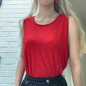 Rött sommar linne  - Rätt linne i bomulls tyg. Perfekt för sommaren eller att ha under en jacka på våren. Bakstycket är längre än framstycket, och den har en slits på sidan. 