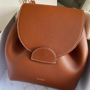 Poléne väska  - The “Numéro Uno Mini Backpack” väska från Polene. Justerbara remmar och kan användas både som ryggsäck och axelremsväska. Nyskick då jag fick den som gåva. Låda och dustbag medföljer Material: skinn Höjd 20,5cm Längd 18cm Djup 9cm Ordinarie pris 290€