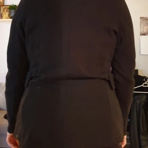 Kavaj - Oanvänd.  Mjukt material. Axlar 42, ärm 65, längd 70.