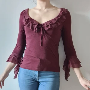 Vinröd topp med knytband och vida ärmar - Sexig vinröd långärmad topp med knytband/knytning i urringningen och meshvolangar i urringningen och på ärmarna. Stil: Mellan Mesh, Vero Moda.  Se sista bilden när banden i urringningen inte är knutna.