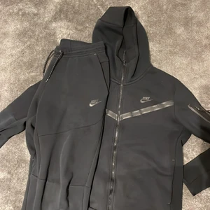 Nike tech tracksuit - En helsvart matchande Nike tech tracksuit. Växt ur den och inte använt den på länge. Båda plaggen är storlek L och den är 8/10 i condition.