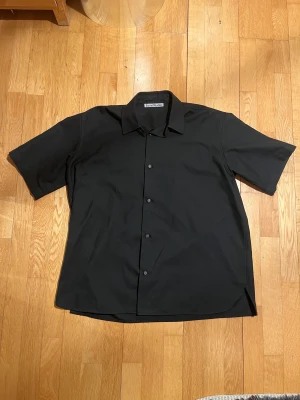 Acne Studios Short Sleeve - Acne Studios short sleeve i svart. Boxy fit.