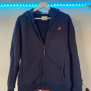 Säljer en marinblå Scotch and soda zip tröja med band över ryggen i storlek 14 junior men passar xs vuxen. Ca 1000kr ny