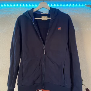 Marinblå Scotch and Soda korta - Säljer en marinblå Scotch and soda zip tröja med band över ryggen i storlek 14 junior men passar xs vuxen. Ca 1000kr ny
