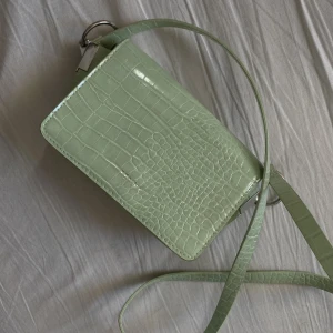 Mintgrön handväska  - Söt liten mintgrön handväska  Finns ett litet innerfack i den. Går även att förkorta axelbandet  Jättefint skick 