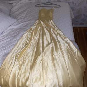 En gul lång balklänning med slits. Använd 1gång, bra skick.  Nypris 1100kr. Mitt pris 800 +frakt.