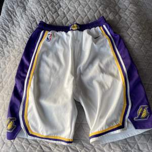 Ett par helt oanvända Lakers shorts  från Nike i barnstolek L, är som nya och har inga defekter🙌🏼