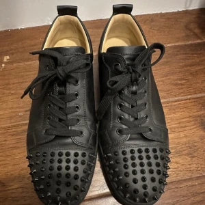 Louboutin  - ”Louboutin Junior spikes”. - Black colorway.  - Kondition: 9/10  - Storlek 41, 42.  - Nuvarande pris på marknaden: 7999kr.  - Köp för 5300kr.  - Som vanligt erbjuder vi fri frakt runt hela EU.  Kontakta oss för fler frågor.  