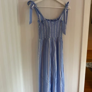 Jumpsuit - Fin, somrig jumpsuit från HM. Ljusblå och vit med knytbara band. Oanvänd, lappen kvar.