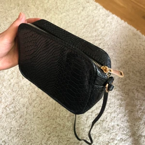 Handväska - Svart handväska/axelremsväska i fakeskinn från ASOS. Köparen betalar frakten.