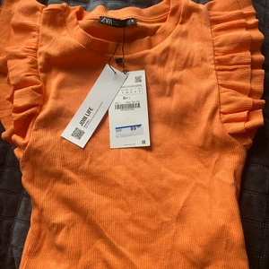 Orange topp  - En fin topp i en fin orange färg (mer röd/rosa än på bilden). Köpt förra året men har tyvärr inte kommit till användning. 