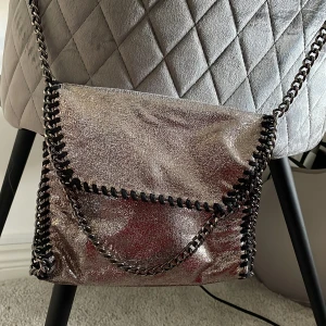 Väska - Säljer en glittrig axelväska med kedjedetaljer🤍Mellanstor 