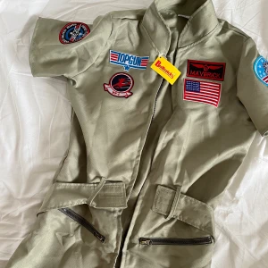 HALLOWEEN Top Gun - Garderobsrensning!!! Kommer mer!!! Säljer denna Top Gun klänning, en halloweenkostym från Buttericks. Aldrig använd! Den är rätt liten i storlek så passar XS/S! Storlek: M Färg: Militärgrön Köparen står för frakten!!!  (OBS! Tryck inte köp nu!)