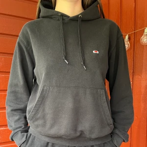 Kärleksbrevshoodie - Svart hov1 Hoodie med kärleksbrev broderat vid bröstet samt en röd liten krona på en av ärmarna. Har tyvärr blivit ganska nopprig på bröstet i tvätten.