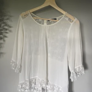 Vit topp - Vit topp i tunnare material med spets i ryggen  