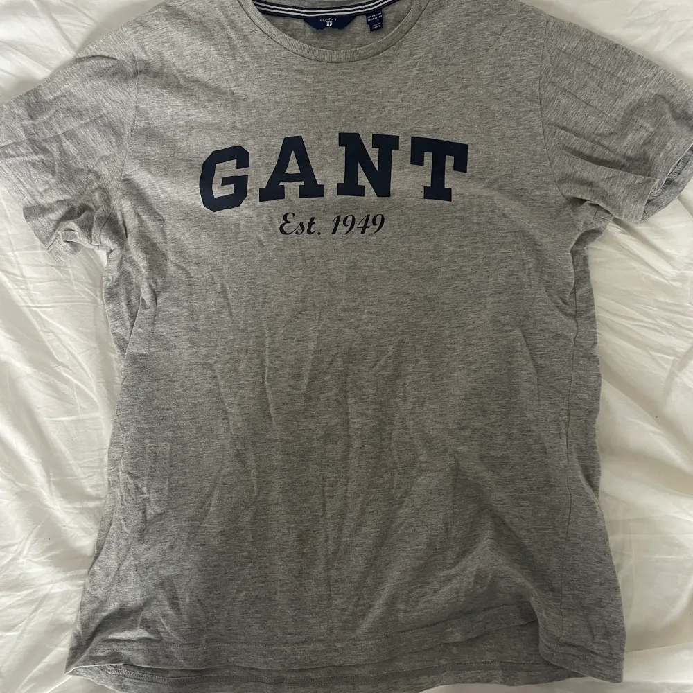 Grå t-shirt från GANT med mörk blått tryck i storlek 158/164 men passar XS. T-shirts.