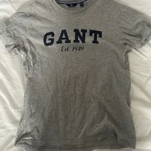 Grå t-shirt från GANT med mörk blått tryck i storlek 158/164 men passar XS