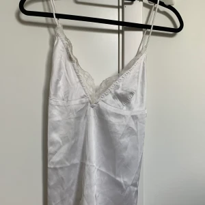 Topp i siden - Vit sidentopp från Nelly. Väldigt fin och smickrande rygg.  Storlek 36.  Aldrig använd  
