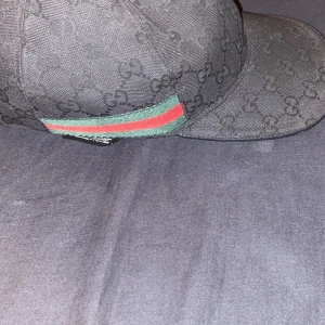 Gucci keps svart äkta storlek m  - Den e i bra skick inga hål inget fel på den storlek m kan mötas upp i stan Göteborg  