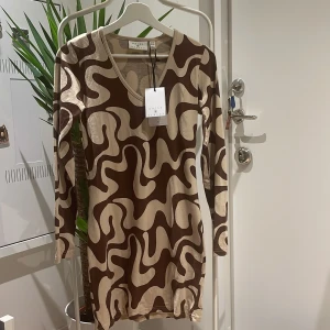 Brunmönstrig bodycon klänning - Säljer då klänningen är för liten för mig. Endast provad, prislapp sitter kvar. Köparen står för frakten.