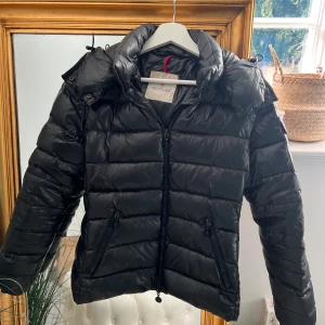 Moncler bady - Säljer min moncler jacka i modellen bady. Svart Storlek 1, passar mig som har S men även XS. Den är i jätte fint skick förutom en liten repa på ena armen, köpt här på plock tidigare. Lite äldre modell. Självklart äkta! Skickas med spårar frakt (PostNord)