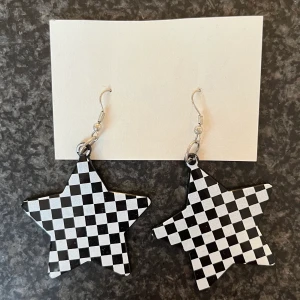 Stjärnformade örhängen med checkered mönster - coola stjärnformade örhängen i "checkered"-mönster! Svarta på baksidan!Det är bara att skriva till mig om ni har några funderingar.