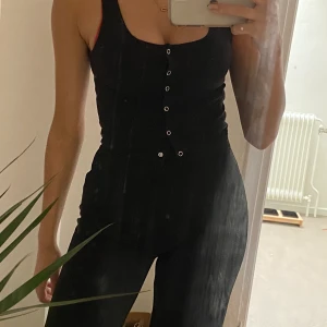 linne med knappar - svart linne med knappar som alla går att öppna. strl S men passar nog en M med då tyget är stretchigt