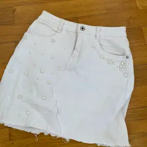 Säljer denna vita jeans kjol med pärl detaljer, storlek 38 och stretchig 