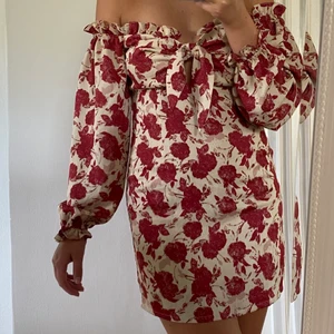 Offshoulder Blommig klänning 🌹 - Superfin offshoulder klänning i begie och vinröda toner🌹. Knappt använd. Klänningen är figursydd längs ryggen och strechig över bysten. Jag är 175 cm. Frakt tillkommer