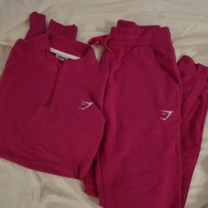 Gymshark mjukisset,flera olika storlekar - Oanvänt mörkrosa mjukisset från Gymshark. Tunt och väldigt skönt material. 500 kr för setet (byxa + tröja). Det går även att köpa bara en del (250 kr) :) Jag har 2 uppsättningar av setet. Har tröjorna i strl S och M, och byxorna i strl XS och S. Byxorna är väldigt stretchiga så skulle säga att XS byxa matchar till S tröja och S byxa till M tröja.