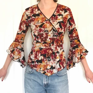 90-talsblus - Fin meshblus med utsvängda ärmar och lettuce hem. Mönstrad i röd/orange/svart/vit. 