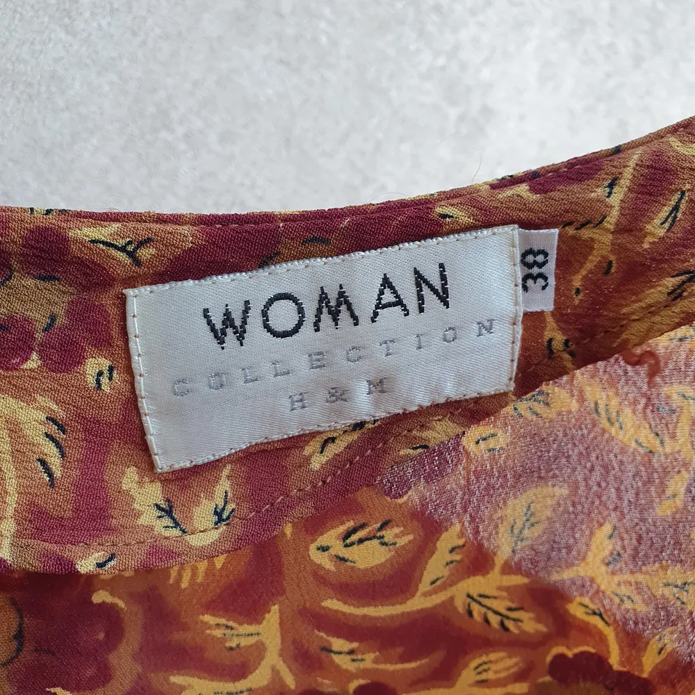 Säljer en fin mörkröd- och beigeblommig klänning från en gammal H&M-kollektion i storlek 38. Passar fint med en tröja under som på sista bilden. Frakt ingår ✨️. Klänningar.