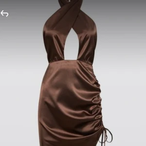 Brun satin klänning från bikbok  - Brun satinklännint i storlek S från bikbok som Hanna schönberg designat! Skulle säga att den även passar en XS då man reglerar halsen själv. Jättefin verkligen men kommer aldrig till användning. Prislappen sitter fortfarande kvar så aldrig använd! Skriv för fler bilder 