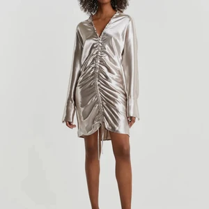 Klänning - En jättefin silvrig klänning, har fortfarande prislappen kvar. säljer då den ej kommer till andvändning.