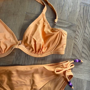 Bikini - Vintage bikini från Bon’a Parte’ beachwear. Orange med lila detaljer. Överdelen är 80B men passar nog bättre på 75B. Nederdelen är strl 42 och passar perfekt på mig som brukar ha 40/M i nederdelar. Frakt 51 spårbart 