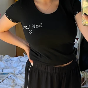 Newbody tshirt S - En vanlig tshirt från newbody med ditmålat tryck ”selflove” och hjärtan på träjärmarna