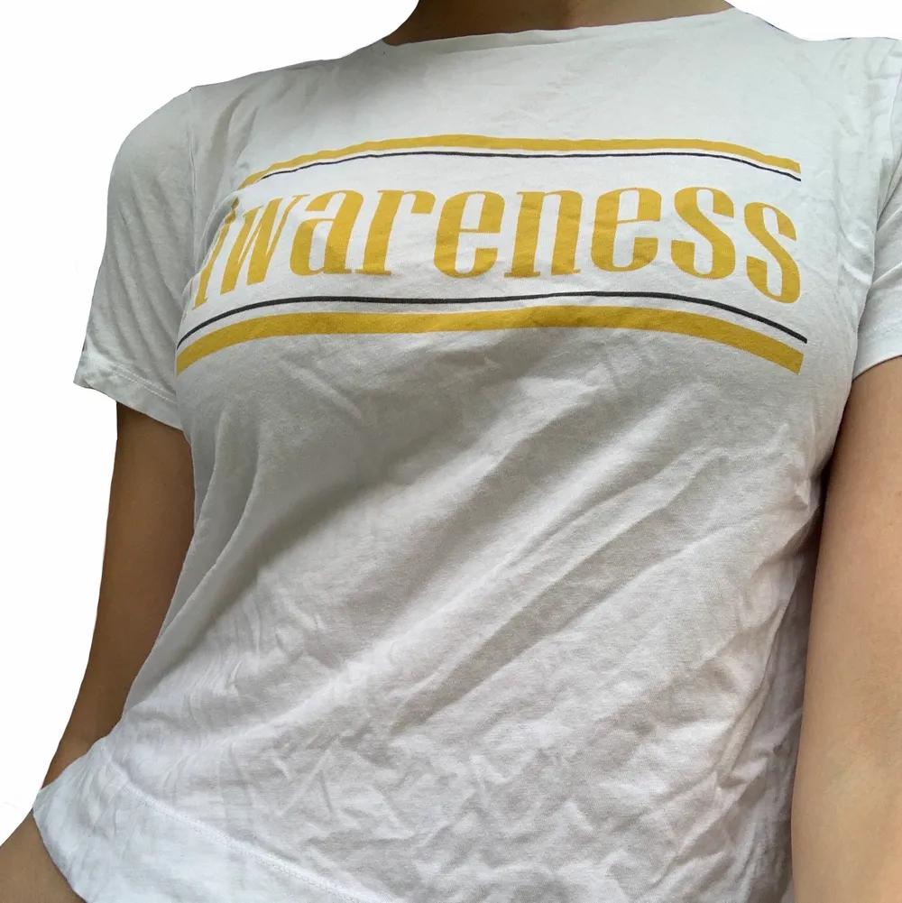Fin vit t-shirt med gul text. (Kan stryka det lite innan jag postar) bra skick☀️. T-shirts.