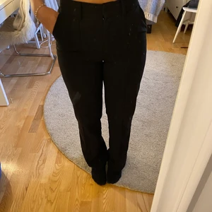 Kostymbyxor m. slits och pressveck - Svarta raka kostymbyxor från NA-KD. Det är slits nertill på baksidan, byxorna har även pressveck fram och bak på vardera ben💞 Nypris: ca 500kr