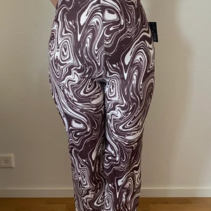 Nelly Crepe Print Pants  - Nelly Crepe Print Pants  Storlek: M Färg: Brun/Mönstrad  Aldrig använda innan, prislappen sitter kvar (de bild).   Obs köparen står för frakten  