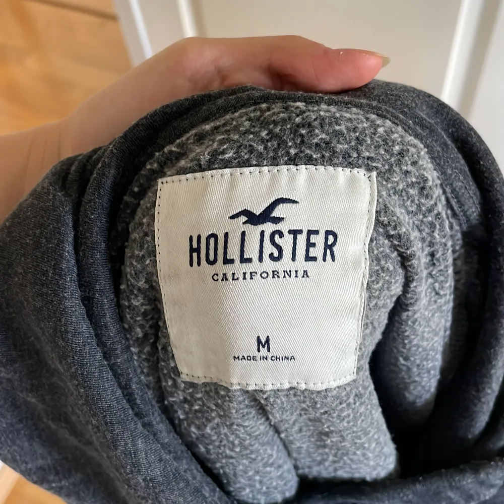 En mörkgrå melerad Hollister hoodie. Lite fluffigt meterial på insidan. Jätteskönt hoodie som går att använda till allt!💗 Kontakta och skriv till mig om frågor eller fler bilder💗. Hoodies.