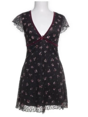 Blommig miniklänning  - Söt kort klänning i spets med små blommor i rosa och vitt, med V-ringning som sitter smickrande. Kan bäras på fest utan något under, eller med underkjol/shorts till vardags 