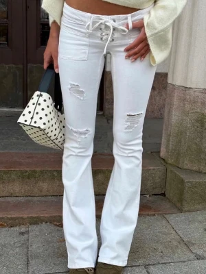Vita bootcut jeans med snörning - Vita bootcut jeans ifårn Gina tricot. I jättebra skick!   Storlek S. De är helt slutsålda överallt. Gina 14+