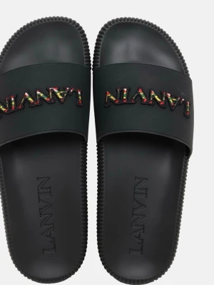 Svarta sandaler från Lanvin - Säljer ett par svarta sandaler från Lanvin med bred rem över foten och färgglad broderad logga. Sandalerna har räfflad sula och är tillverkade i syntetmaterial. Perfekta för en chill och trendig look. Nypris 3800kr säljer för 2299