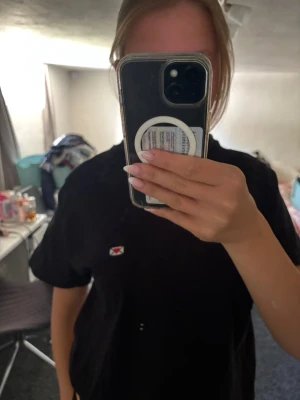 Hov1 merch med kärleksbrev detalj  - KÖPT PÅ GÄRDET 29 AUGUSTI 2025!!! En svart hov1 t-shirt (från stockholms konsert förra sommaren) i bomull med en liten broderad patch framtill som föreställer kärleksbrevet. Klassisk passform och korta ärmar, perfekt till jeans eller kjol för en chill look.