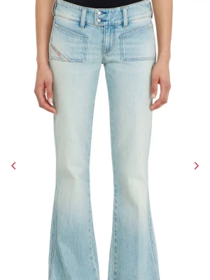 Ljusblå bootcut jeans med fickor - Säljer ett par ljusblå bootcut jeans med utsvängda ben och stora framfickor. Jeansen har dubbla knappar i midjan och en cool tvättad look. Perfekta för dig som gillar retrostil och vill ha något bekvämt och trendigt i garderoben.