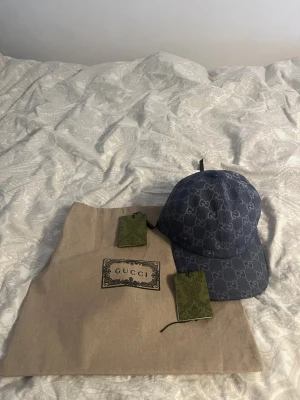 Blå Gucci keps med monogram - Säljer en blå keps från Gucci med det klassiska GG-monogrammet över hela kepsen. Kepsen har böjd skärm och justerbar rem bak. Tillverkad i Italien och levereras med originalpåse och tags. Perfekt för dig som vill ha en lyxig och trendig accessoar. Kepsen är Äkta Såklart använd Max 5 gånger kom med ett bud eller två 👊👊😁