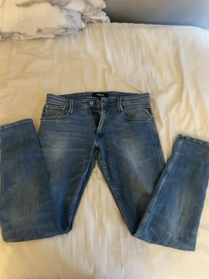 Replay anbass jeans - Säljer ett par klassiska blå jeans från Replay. Jeansen ljus tvätt, samt detaljerade sömmar på bakfickorna. Perfekta till en avslappnad stil och passar till det mesta. W31, L32. Hör av dig vid funderingar!