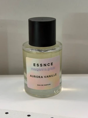 Aurora Vanille parfym från Essnce - Aurora Vanille Eau de Parfum från Essnce x Margareta Grääs. Flaskan är genomskinligt glas med svart rund kork och en ljus etikett. Doften har inslag av vanilj. Har bara test sprejat den några gånger :)